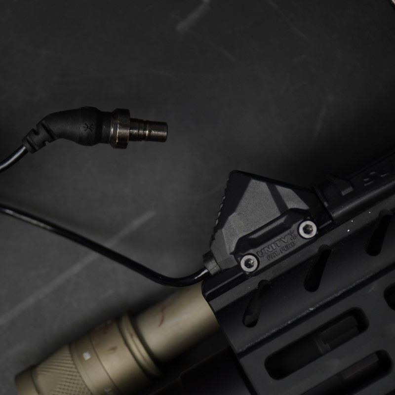 SureFire AXON Light Switch mit zwei Tasten zur unabhängigen Steuerung von Licht und Laser. Das Kabel ist 17,8 cm lang und hat Anschlüsse für SureFire- oder Modlite-Tailcap-Ports. Die robuste Bauweise und die ergonomische Gestaltung ermöglichen eine einfache Bedienung.